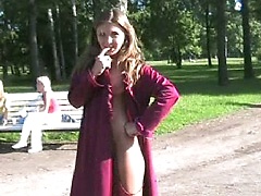 Seductive exhibitionist opens her coat in park