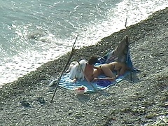 Horny beach couple try to conceal their sex act
